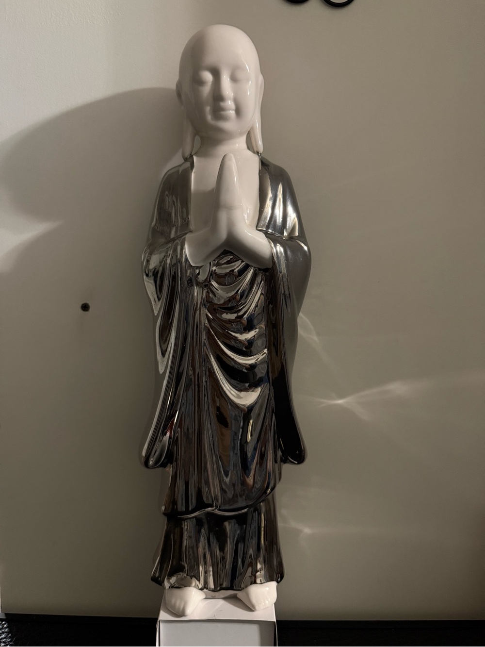 figurine resembling a praying monk statue white porcelain head and a metallic,